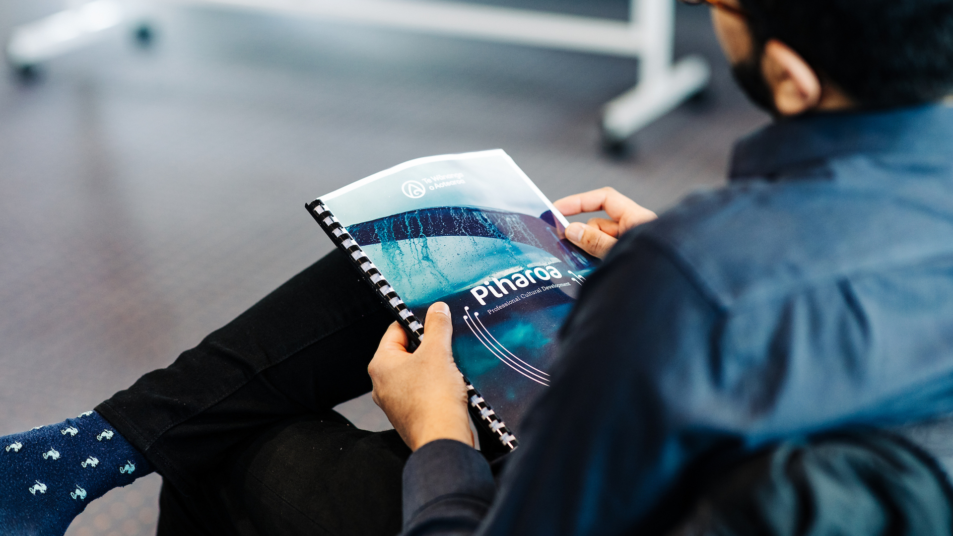Close up of an attendee reading the Piharoa handbook