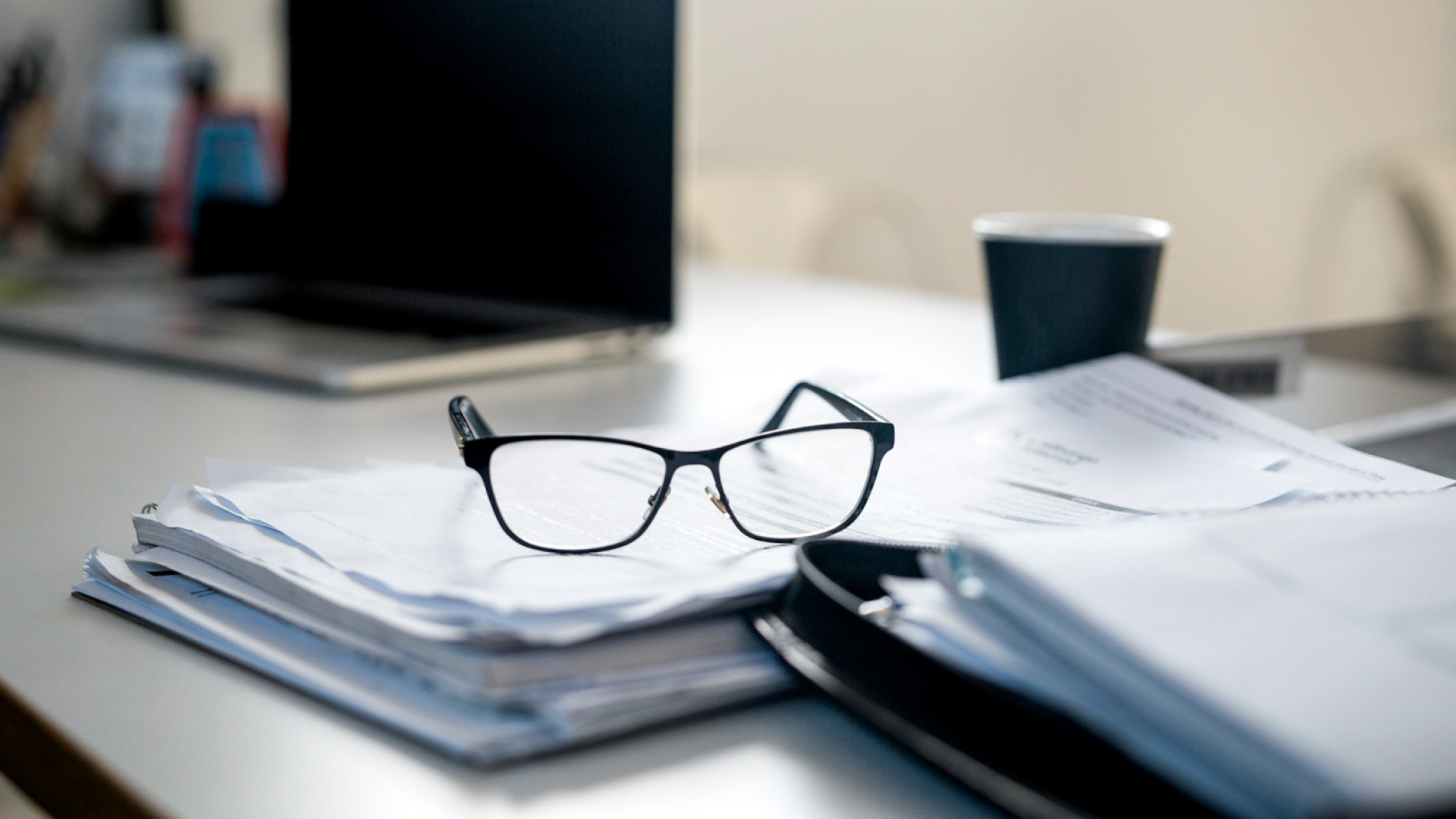 Prescription glasses on top of documents on an office desk